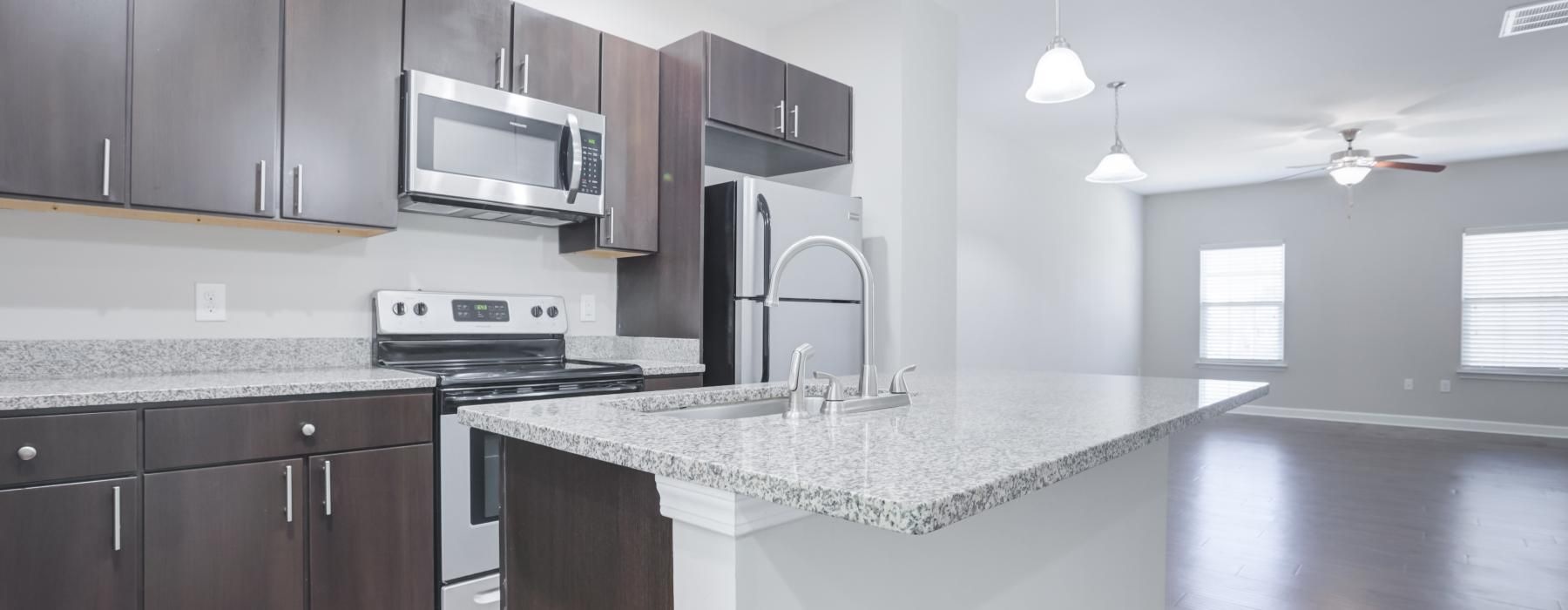 Kitchen with stainless appliances and kitchen island at Charleston Row apartments in Pineville, NC