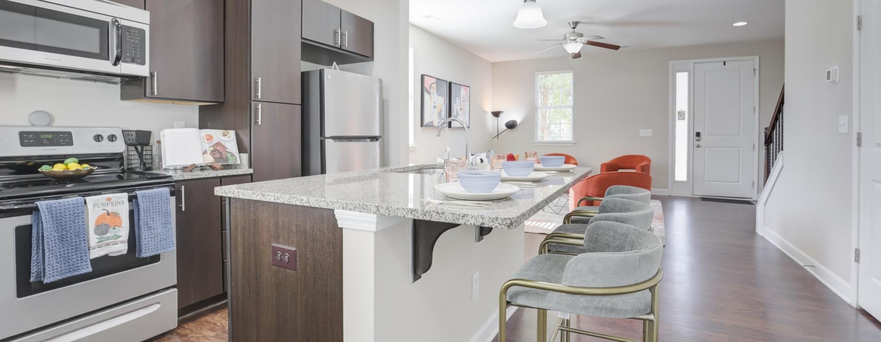 Kitchen with island and stainless appliances at Charleston Row 2 and 3 bedroom townhome apartments in Pineville, NC